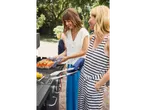 Duas mulheres preparando salmão na churrasqueira.