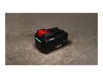 A black power tool battery with red accents and a green indicator light, on a concrete surface.