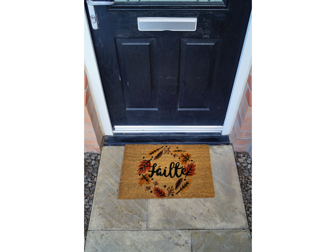 Autumn coir doormat in front of a black front door