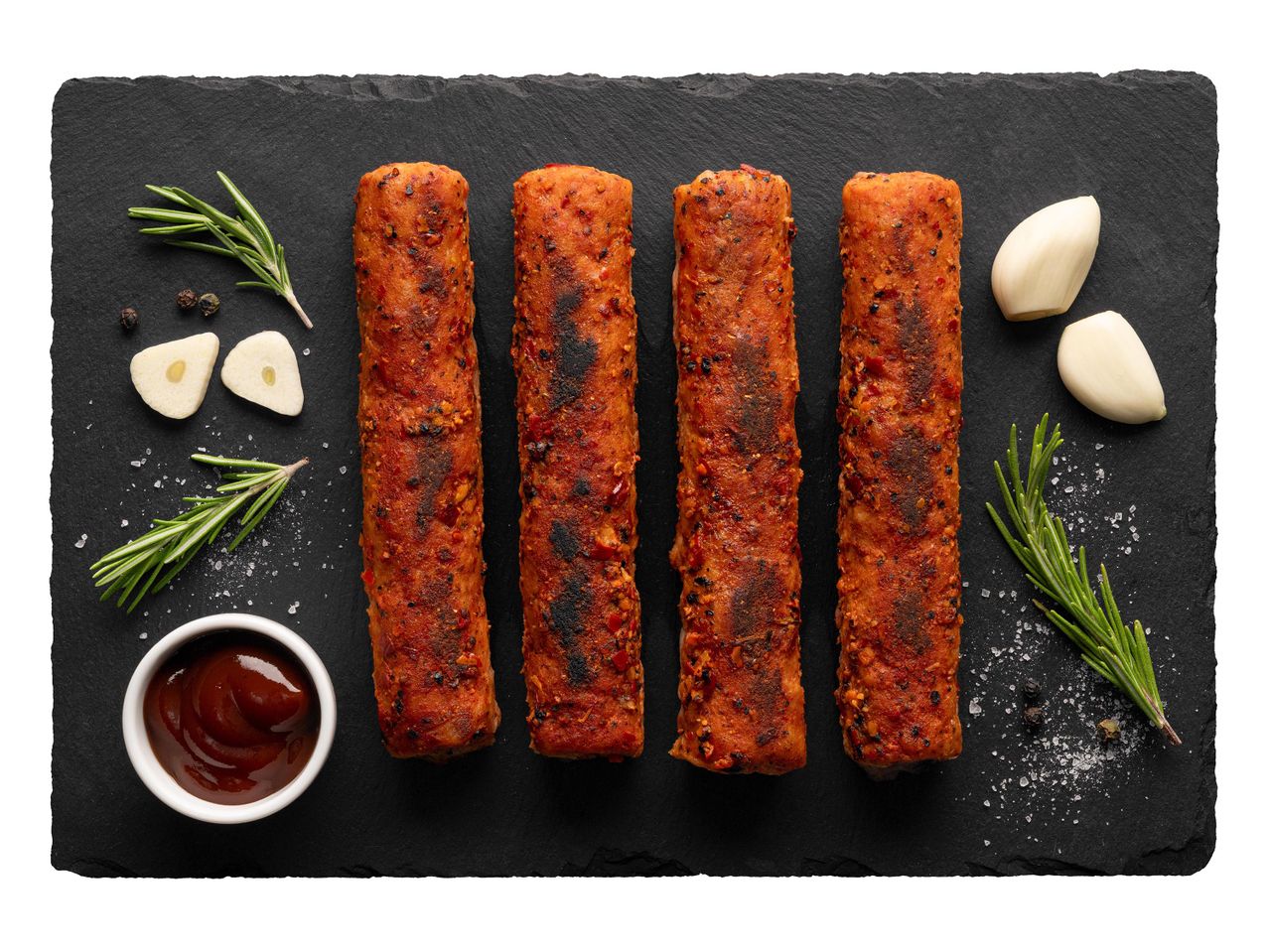 Négy grillezett vegetáriánus kolbász, fokhagymával és BBQ szósszal.