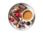 Chocolate-covered nut bars, raspberries, and coffee on a plate.