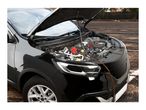 An electric oil extractor pump connected to a car engine under an open hood.