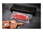 SilverCrest vacuum sealer with a vacuum-sealed steak, garlic, and peppercorns on a board.