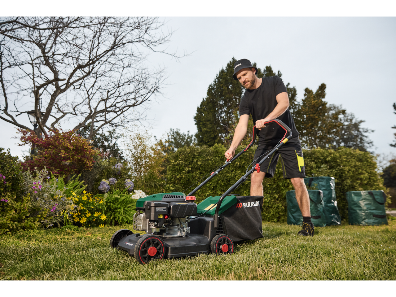Man mowing lawn with a Parkside lawnmower.