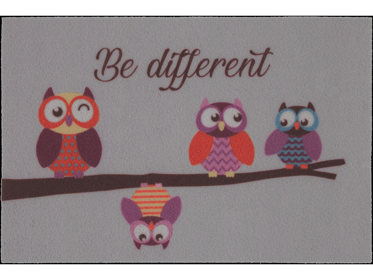 Три сове на грани; весела, шарена простирка са текстом 'Be different'.