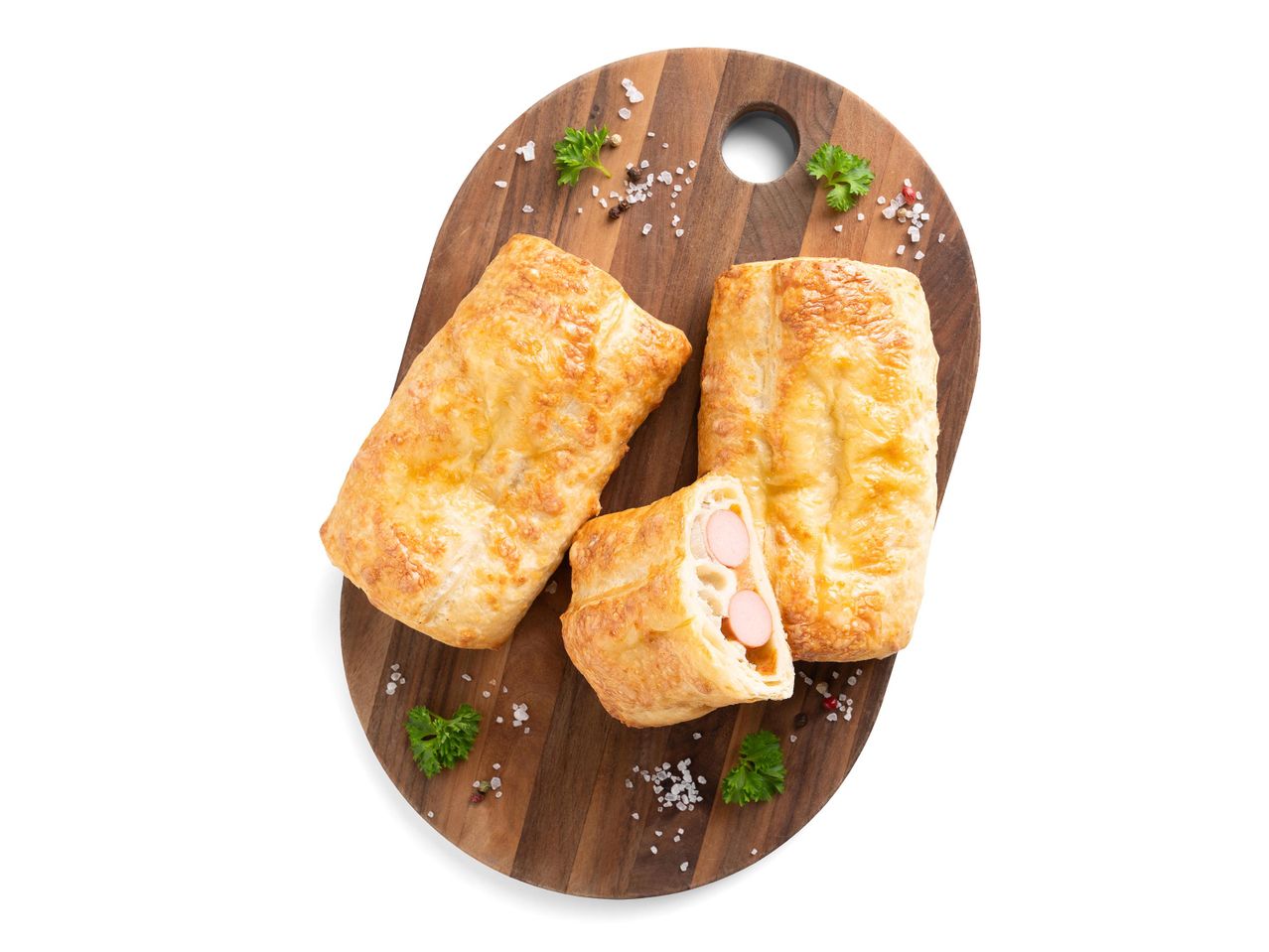 Sajtos virslis tésztafalatok vágódeszkán, petrezselyemmel és fűszerekkel.