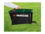 A person holding a black and green grass collection box with a red accent over green grass.