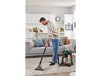 A man cleans a rug with a Parkside wet and dry vacuum cleaner in a modern living room.