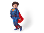 A young boy in a blue Superman costume with a red cape and blue sneakers.