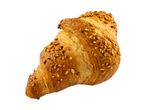 A golden-brown croissant topped with chopped nuts, isolated on a white background.