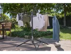 A Brabantia rotary clothes airer stands in a sunny garden, drying various clothing items.