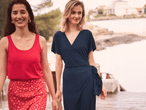 Zwei Frauen tragen sommerliche Kleidung: ein rotes Top und einen Wickelrock, ein dunkelblaues Wickelkleid.