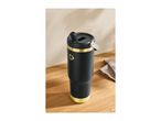 Black and gold insulated tumbler with a straw lid on a wooden surface.