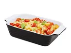 Baked pasta with cherry tomatoes, cheese, and basil in a black and white baking dish.