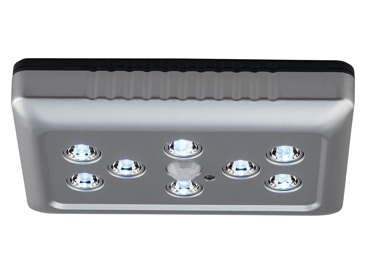 A silver rectangular LED light with a black top, featuring eight bright lights and a central sensor.
