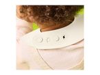 Close-up of a baby wearing a cream-colored bib with adjustable fasteners.