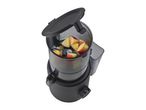 Black juicer with an open lid, filled with apple pieces, on a white background.