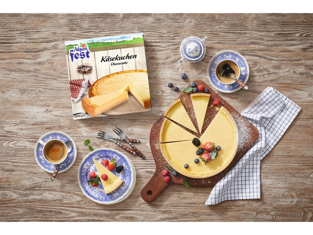 Alpenfest Käsekuchen (cheesecake) and coffee served on a wooden table.