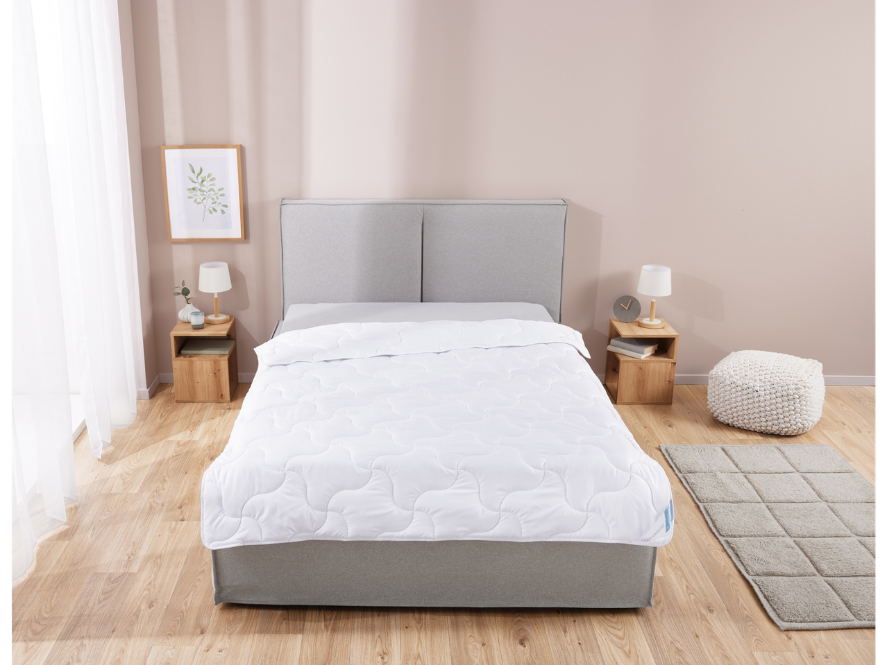 White quilted duvet on a bed in a bedroom.