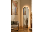 Sala de estar com espelho retroiluminado, pintura abstrata e poltrona aconchegante.