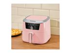Pink air fryer on a wooden counter with a plate of fries and cream tiles in the background.