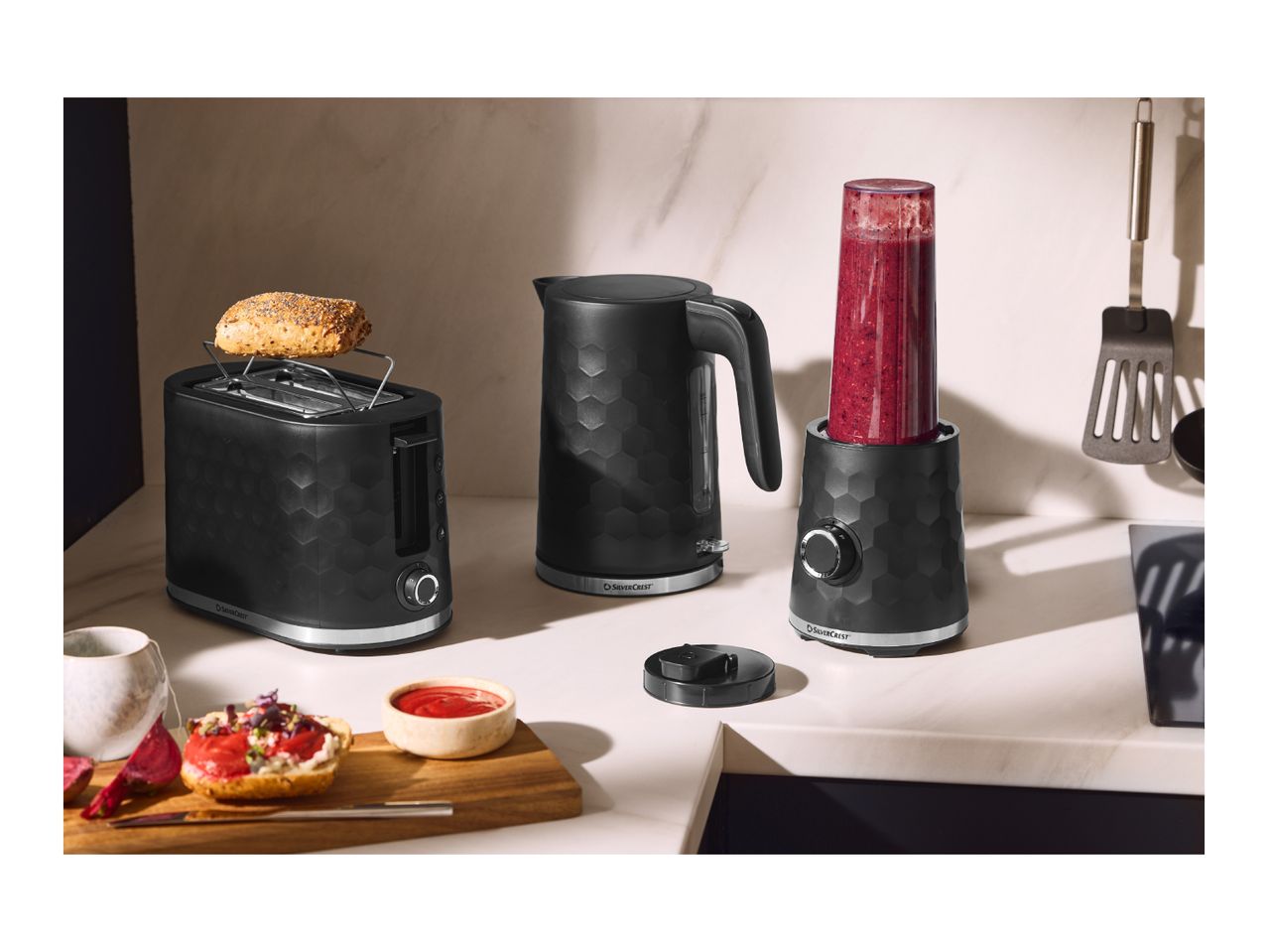 Black toaster, kettle, and blender with a honeycomb pattern on a kitchen counter.