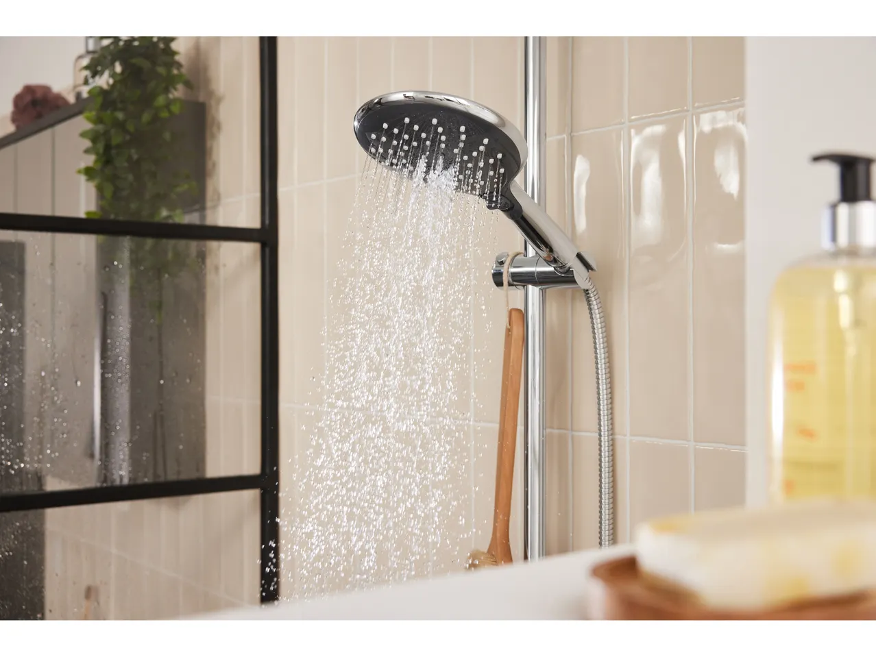 Doccetta a soffione in un moderno bagno, con dispenser di sapone e saponetta.