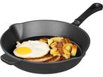 Cast iron skillet with fried egg, sausages, and roasted potatoes.
