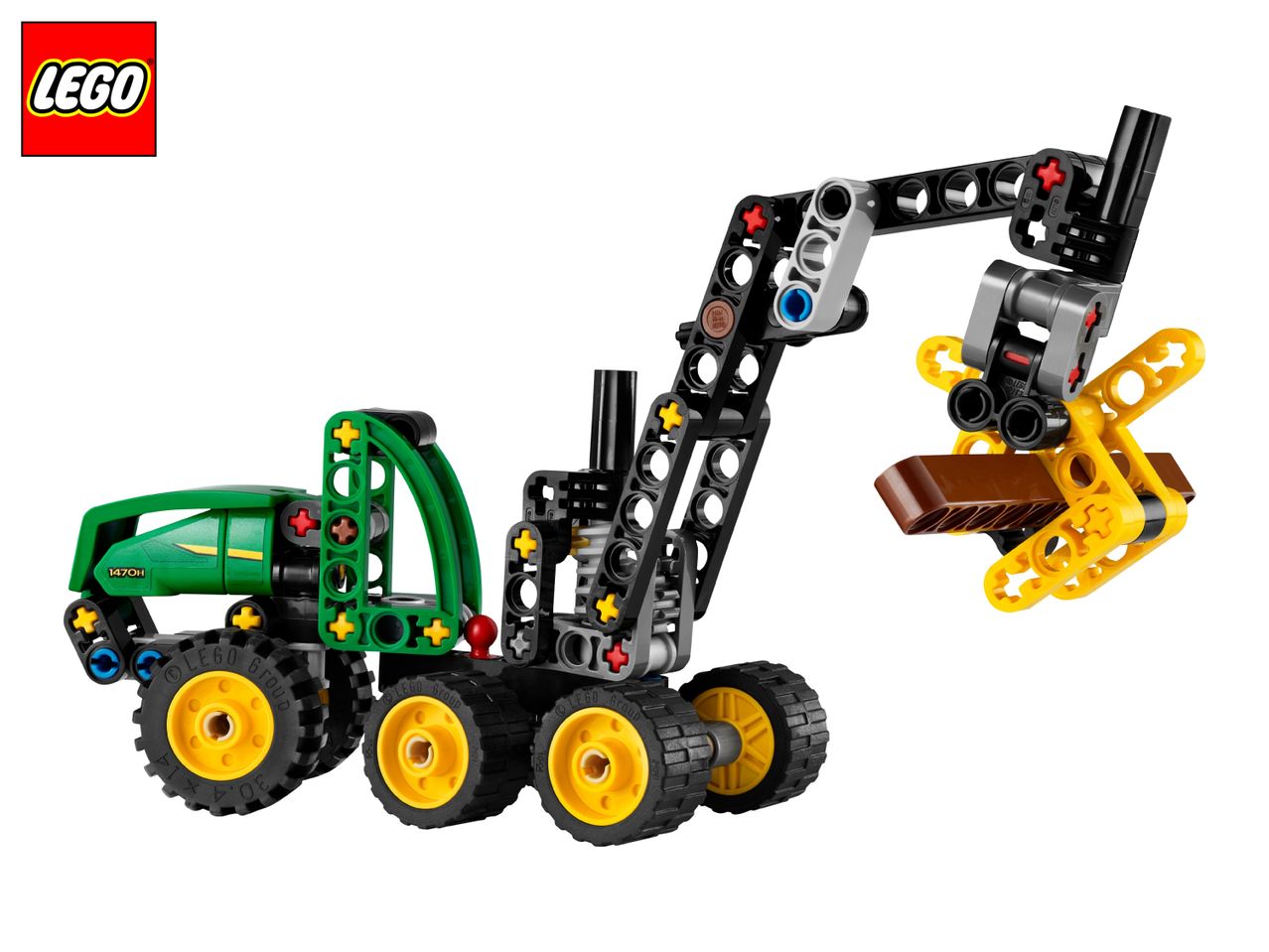 Green and black toy tractor with a crane arm holding a brown log piece.