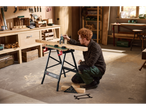 Man measuring wood on a workbench in a workshop