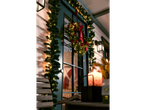 Christmas wreath and garland with lights on a house exterior at night