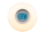 A white circular alarm clock with a digital display showing 6:01 and 1:12, and the date 10/9 WE.
