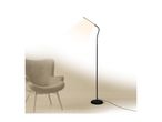 Black floor lamp with a bright light next to a beige armchair in a minimalist room.