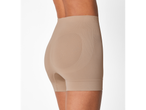 Vista lateral de uma mulher a usar calções modeladores bege.