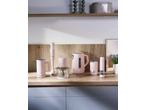 Eletrodomésticos de cozinha rosa, incluindo varinha mágica, picadora, chaleira e moedor de pimenta, numa bancada de madeira.