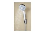 A chrome shower head with blue nozzles spraying water against a beige wall.