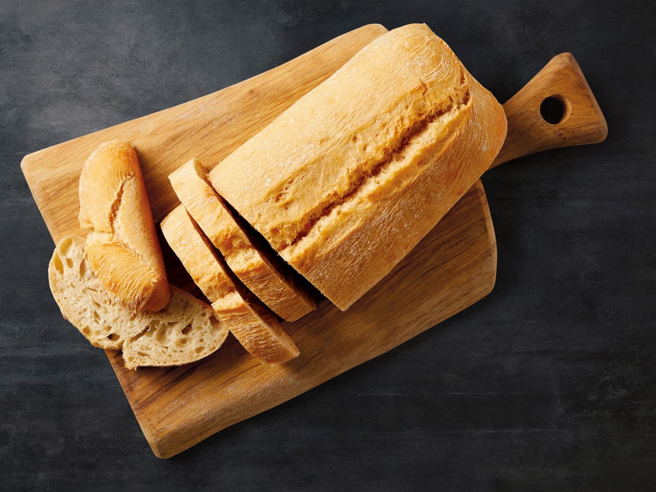 Ciabatta Brot in Scheiben geschnitten auf einem Holzbrett.