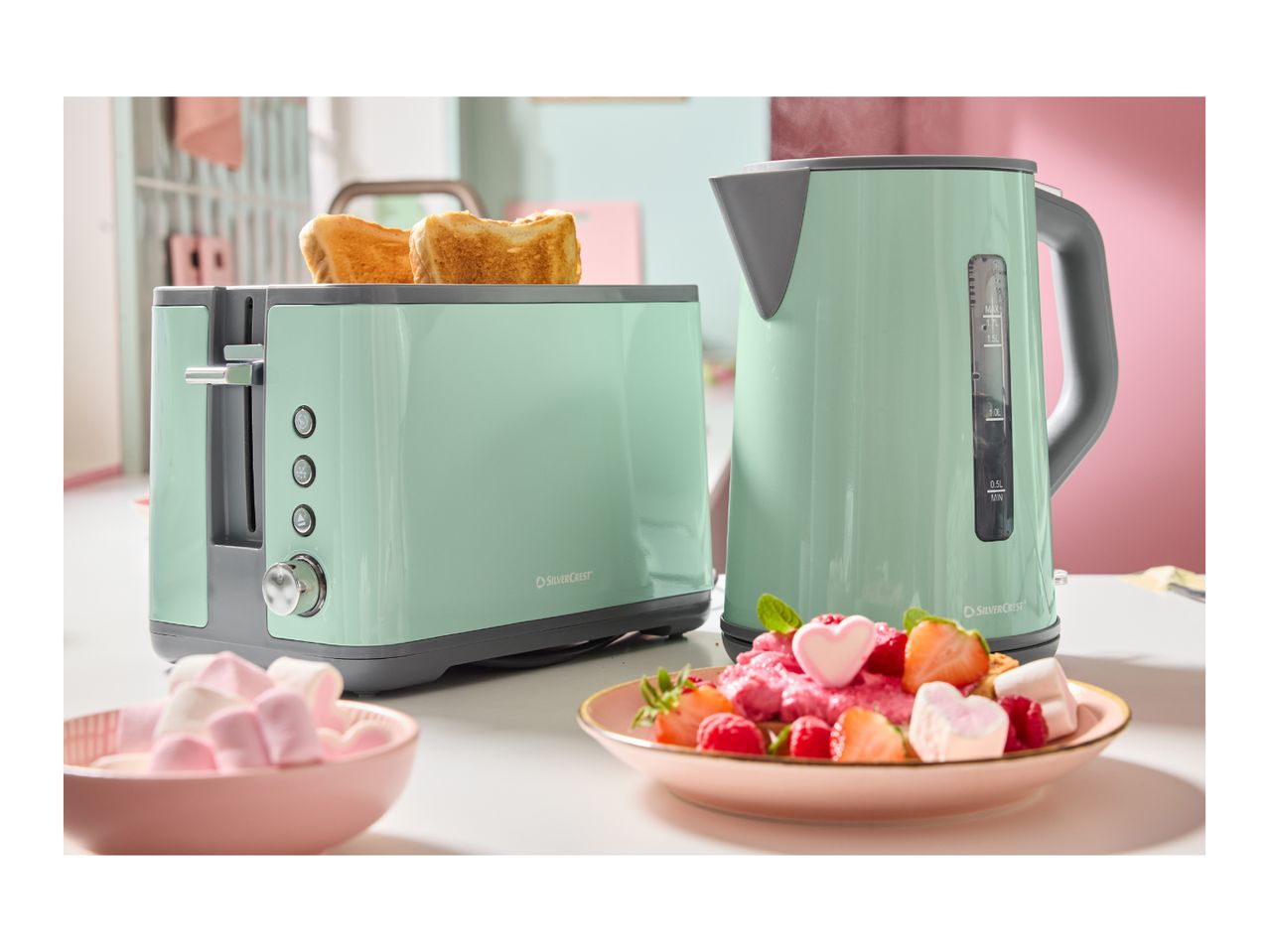Mint green SilverCrest toaster and kettle with toast, fruit, and marshmallows.
