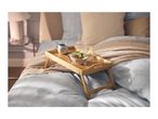 Breakfast in bed with a wooden tray holding a bowl of yogurt, fruit, a mug, and water.