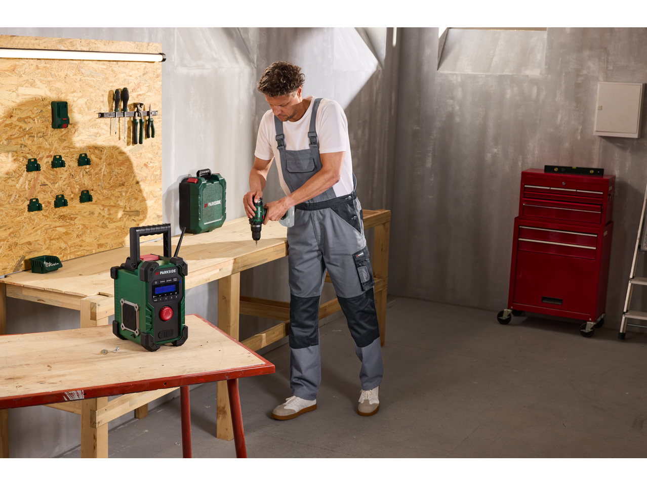 Man in werkplaats met PARKSIDE accuboormachine en radio.