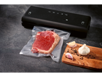 Вакуумна машина Silvercrest® с вакуумирано месо и чесън върху дървена дъска.