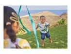 A boy in a dinosaur t-shirt and denim shorts plays with a ribbon outdoors.