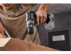 Bărbat care găurește lemn cu un ciocan rotopercutor fără fir PARKSIDE PERFORMANCE 20V, creând rumeguș.