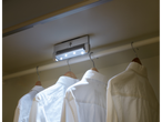 LED-verlichting in een kledingkast met witte overhemden aan hangers.