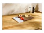 A wooden and marble serving board with cheese, dip, and tomatoes on a wooden counter.