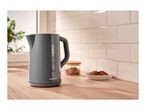 A dark grey SilverCrest electric kettle on a wooden countertop with cookies and sugar.