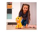 A young girl with pigtails smiles while holding a yellow plush lion toy on a wooden floor.