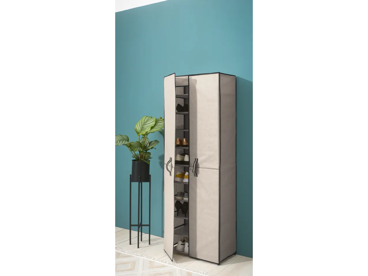 Beige fabric shoe cabinet with black metal accents against a teal wall.