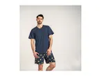 Man in a navy blue V-neck t-shirt and navy blue shorts with a lemon pattern.