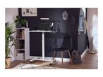 Home office with height-adjustable desk, laptop, chair, and shelving unit.